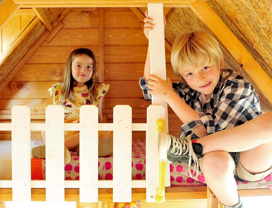 Petits Belges jouant dans une cabane en bois à l'extérieur