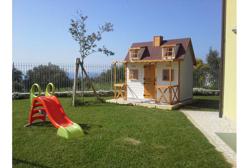 Kinder spielen in einem hölzernen Spielhaus im Freien