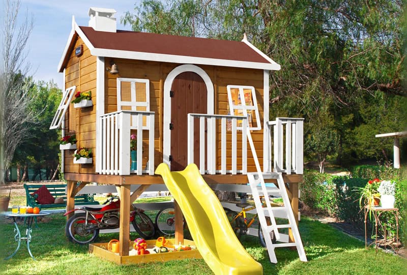 Enfants jouant dans une cabane en bois à l'extérieur