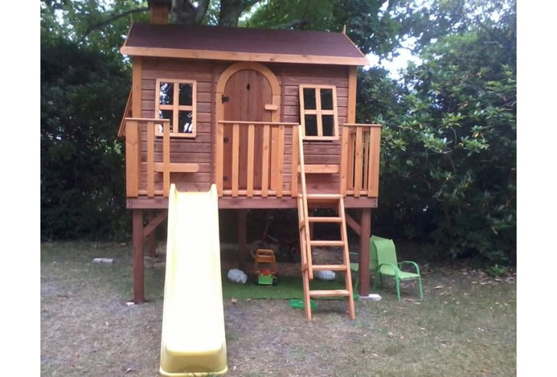 Enfants jouant dans une cabane en bois à l'extérieur