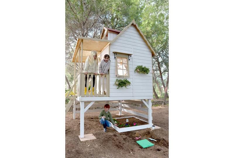 Enfants jouant dans une cabane en bois à l'extérieur