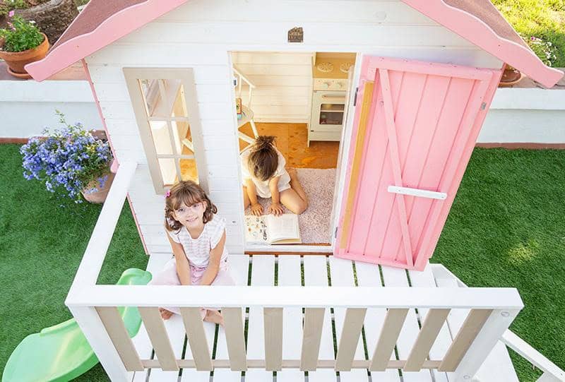 Bambini che giocano in una casetta di legno all'aperto