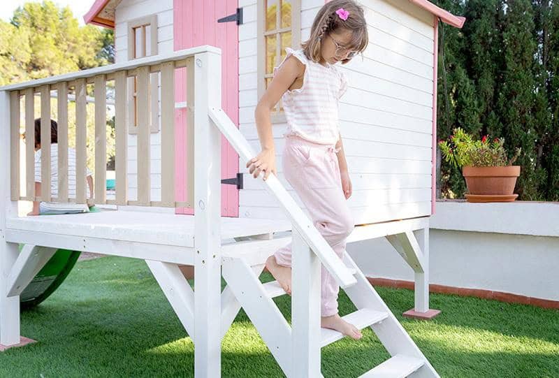 Bambini che giocano in una casetta di legno all'aperto