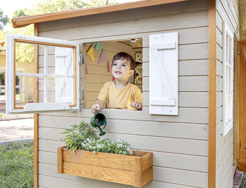 Bambini che giocano in una casetta di legno all'aperto