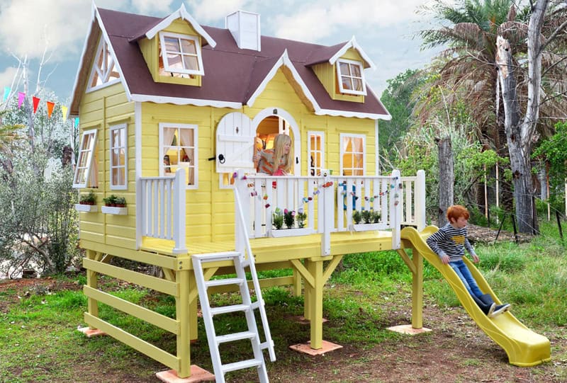 Crianças brincando em uma casinha de madeira ao ar livre