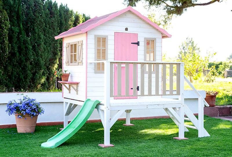 Crianças brincando em uma casinha de madeira ao ar livre