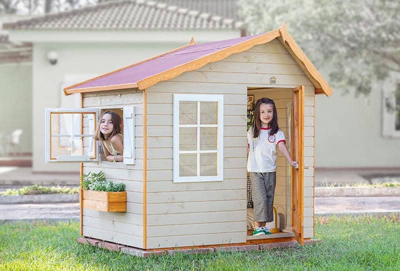 Crianças brincando em uma casinha de madeira ao ar livre